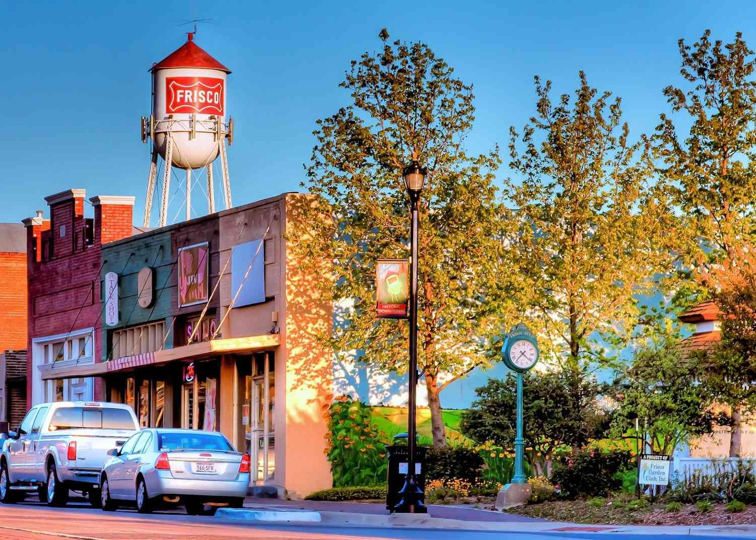 Historic downtown Frisco streetscape with the Frisco water tower above brick storefronts.